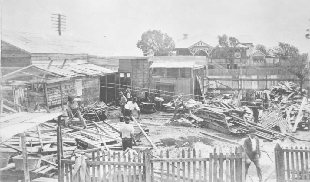 Workers clear a cyclone damaged house at Mackay, 1918