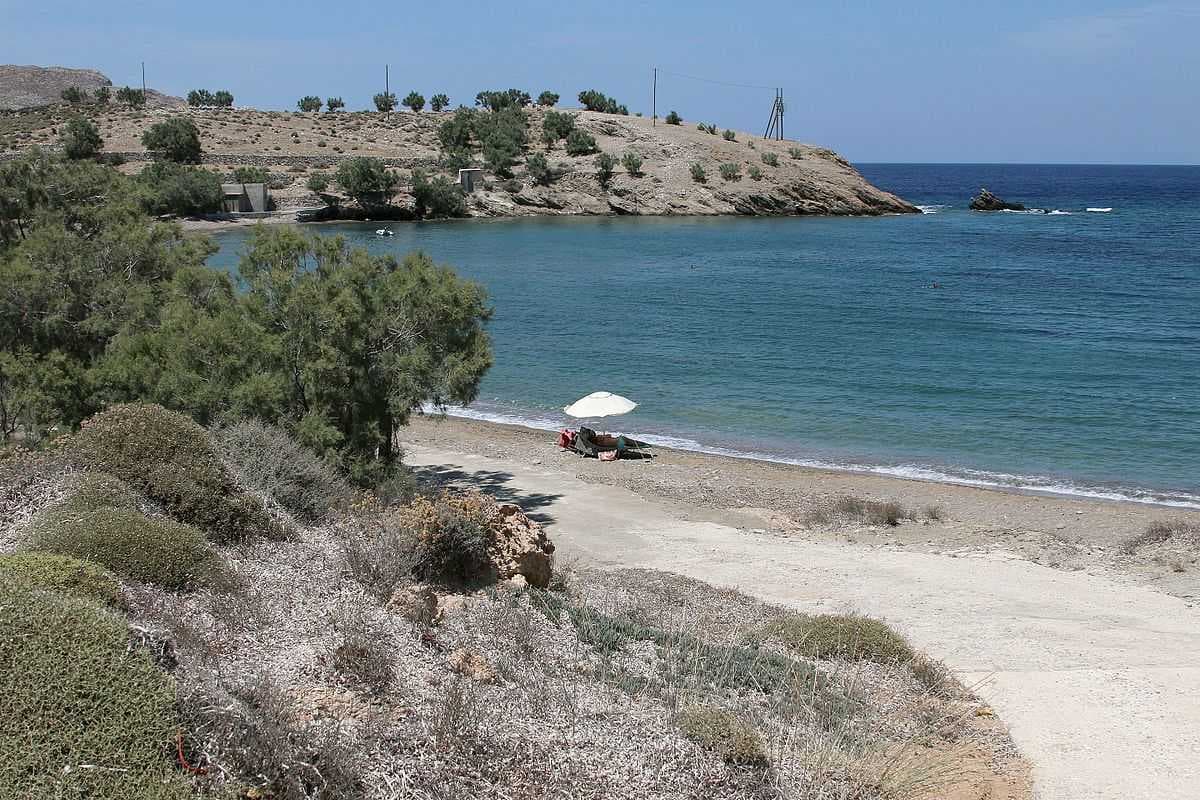 A family camped under sun umbrella at Livadaki Beach