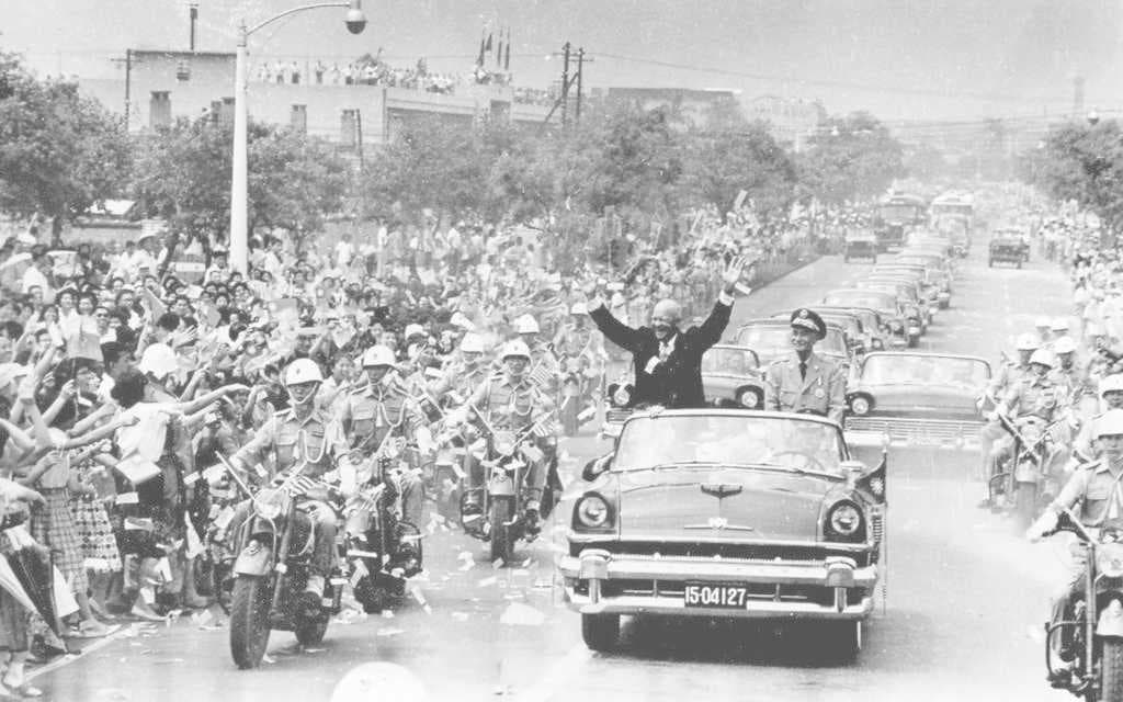 With President Chiang Kai-shek, U.S. President Dwight D. Eisenhower waved to a crowd during his visit to Taipei in June 1960.