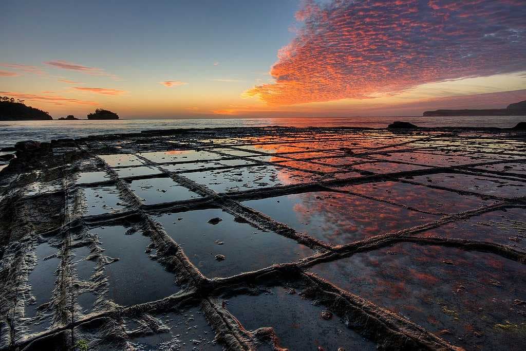 Sunrise on the tessellated pavement at Eaglehawk Neck, Tasmania, illustrating the pan formation of tessellation
