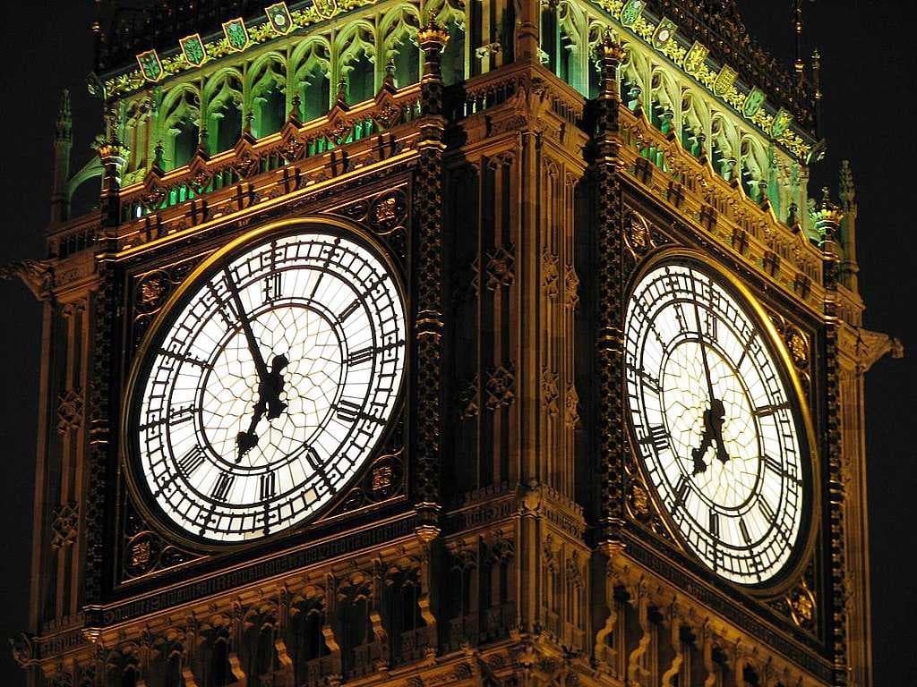 Big Ben's dials and belfry are illuminated at night.